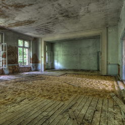 Verlassener Raum mit Sand und alten Fenstern.